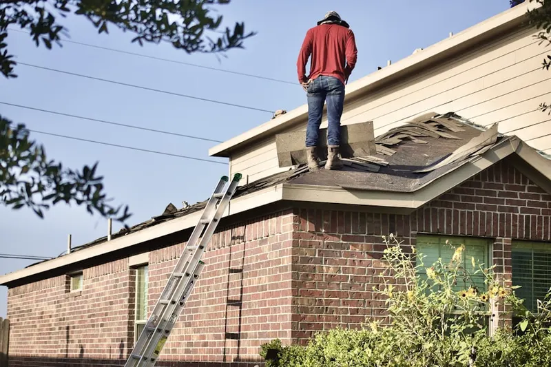 Professional roofer working on a residential roof in Newland